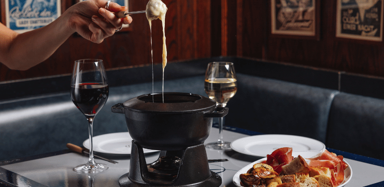 Fondue pot and wine glasses on a table